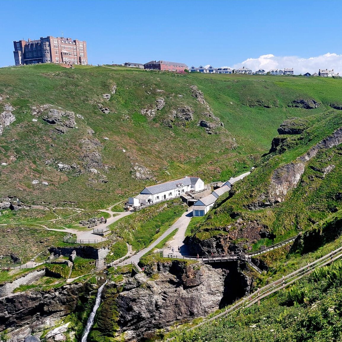 a view over a steep and rocky valley featuring buildings old and new